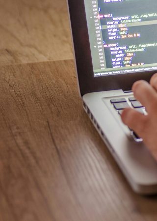 Close-up of a person coding on a laptop, showcasing web development and programming concepts.